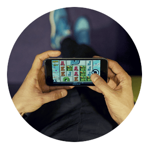 Hands holding a phone with a slot game